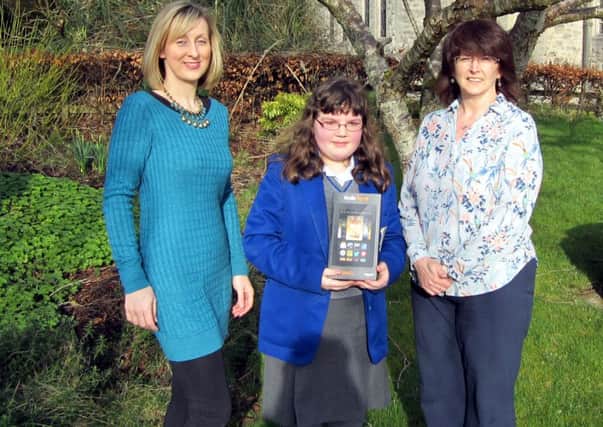 English teacher Mrs. C Blaney and right head of year 8 Mrs. U Cosgrove with 8L student Caitriona McToal who won the Kindle Fire HD awarded for The Big Book Hunt. INLT 11-661-CON