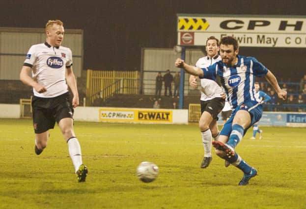 Eoin Bradley keeps the Dundalk defence on their toes by shooting on sight at Coleraine Showgrounds.