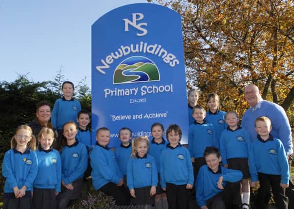 Pupils modeling the new uniform at Newbuildings Primary School. Included are Chris Scholes, Principal, and local artist, Bridget Murray, who designed the new logo for the school. INLS4511-147KM