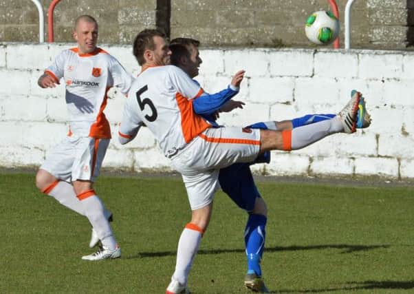Carrick's Glenn Taggart hooks the ball clear in last Saturday's 1-0 win over Coagh United.