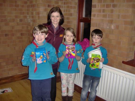 Ann Patterson, PR ambassador, presenting 4th Carrickfergus Beavers with their prizes following the Sainsbury's Carrickfergus Fairtrade colouring in competition: (from left) winner, Jamie and runners-up Sophie and Ethan.  INCT 11-608-CON