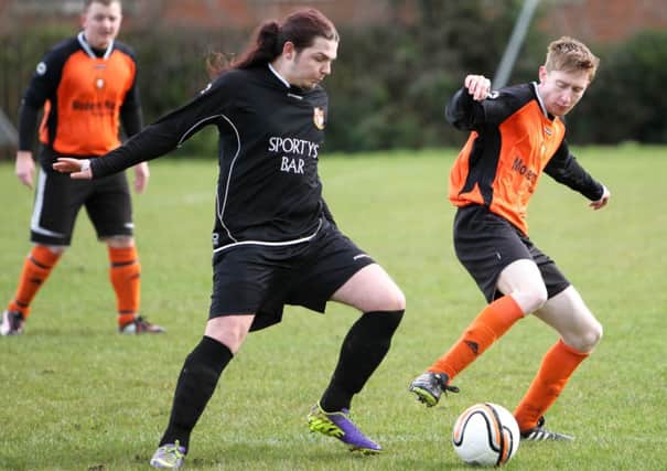 Two players battle for possession in the game between 3rd Ballyclare OB and AFC Carrick.