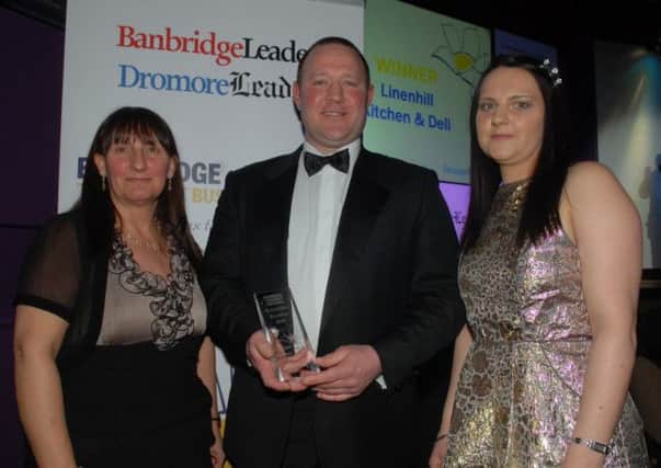 Audrey and Melissa Edens from Bella Bambinos sponsors of the Best Outlet Business Award present the trophy to Linenhill Kitchen and Deli represented by John Robinson. INBL1214-BUSAWARDS41