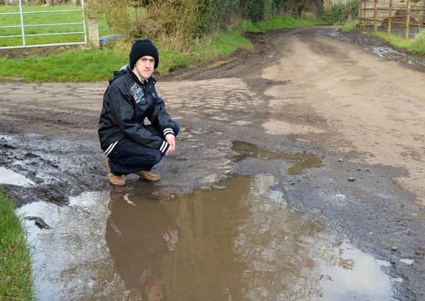 Gerard O'Neill pictured at one of the large flooded potholes on the Tullydagan Road. INLM13-211.