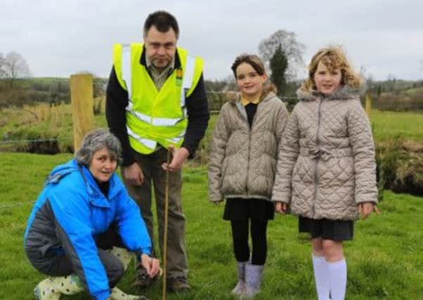 Mrs Spratt with Victoria & Amy from Fairhill Primary School Kinallan help Michael Shanks plant a tree.