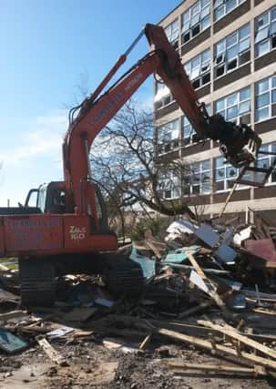A track digger crushes and moves debris at the former St Peter's High School.