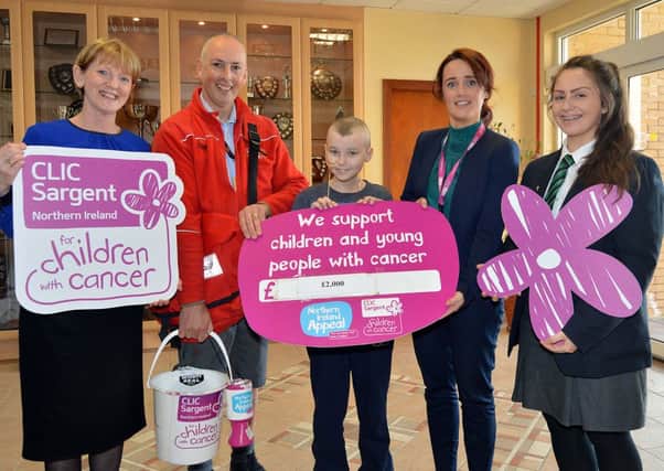 Craigavon Postman Dan McAlinden, swecond from left, and his daughter, Lismore pupil, Caitlin, right, have raised £2079.20 for the Clic Sargent childrens cancer charity. Dan wore his Roal Mail uniform shorts throughut the winter and Caitlin organised a bun sale at the school. Pictured with the father and daughter team at the presentation of the cheque are from left, Mrs Dolores Foster, vice principal, Jack Nelson, local cancer sufferer, and Fiona McCann, Clic Sargent fundraising manager, Armagh/Down. INLM12-200