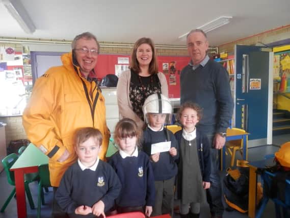 RNLI volunteers Steven Craig and Robert Rice with teacher Mrs Kidd and pupils Oliver McDowell, Erin OBrien, Alistair Todd and Jessica Smyth during their visit to Whitehead Primary School.  INCT 13-702-CON