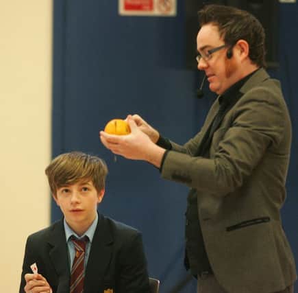 Downshire year 11 pupil Ross Lough volunteers to take part in a magic trick during the Cahoots NI performance at the school. INCT 14-703-CON
