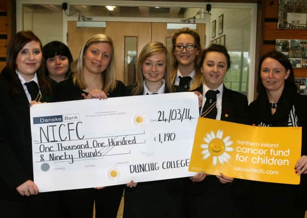 Dunclug College pupils Sophie Smyth, Hanna Smyth, Nicola Millar, Chloe McCook and Chelsea Thompson are pictured presenting a cheque for £1190 to Rebecca Spiers of the Northern Ireland Cancer Fund for Children. The money was raised from the schools Daisy Day. Included is teacher in charge Mrs. Lee. INBT14-200AC