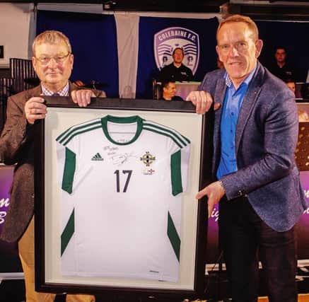 Kenny Shields presents Hugh Wade with a signed Northern Ireland shirt from his son Dean to add to his Manchester United collection.