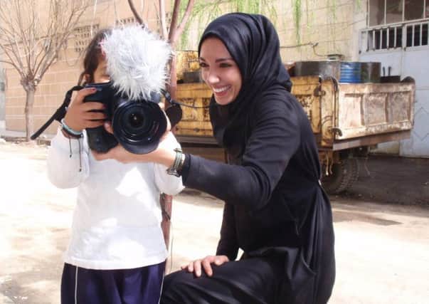 Yasmin Al Tellawy shows this young Syrian child her camera. INLT 14-654-CON