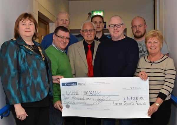 Martin Wilson, chairman of the Larne Sports Forum, and members present a cheque for £1,120 to Mayor of Larne Maureen Morrow for her chosen charity the Larne Foodbank. The money was raised at the Larne Sports Awards charity raffle sponsored by P & O. INLT 14-005-PSB