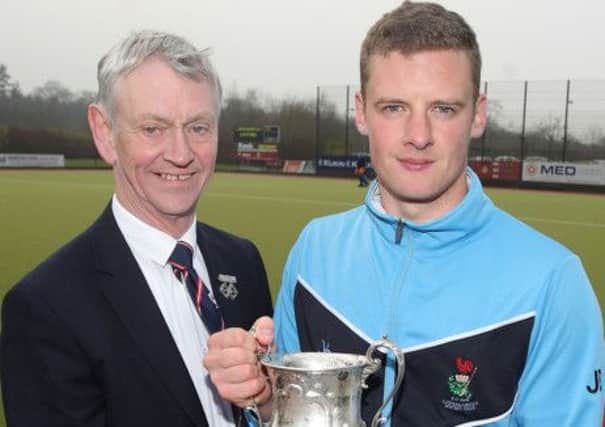 Billy Stewart, Ulster Hockey president, presents the Ulster Premier League trophy to Lisnagarvey hockey captain Jonny Bell, the club's 37th Premier League title following a 7-0 victory against Raphoe. US1414-559cd Picture: Cliff Donaldson