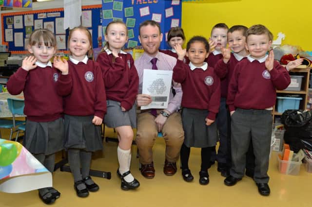 Principal of Ballyhenry Primary, Mr Robert Smith, with some of the school's P1 and P2 pupils after they received their "very good" inspection report. INNT 14-001-PSB