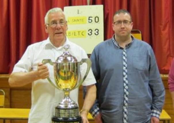 Don Montgomery, chairman of All Saints BC, and Alan McCord with the John Logan Memorial Cup. The Saints defeated LB & LTC in the final. INLT 14-912-CON