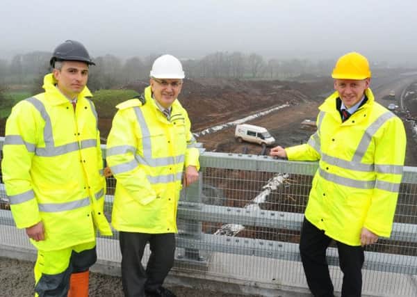 Transport Minister Danny Kennedy (centre) with Cesar Sierra (left), project manager, Lagan Ferrovial Costain, and Colin Hutchinson, Department for Regional Development Roads Service project sponsor. INLT 15-678-CON