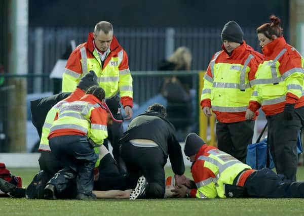 Derry City's Ryan McBride is treated on the pitch before getting stretchered off.