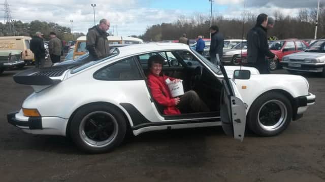 Culture Crew volunteer, Pam Hardeman, who was collecting in aid of Cancer Focus at Eglinton Classic Car Show on Saturday, takes a shine to an immaculate 1987 white Porche 911.