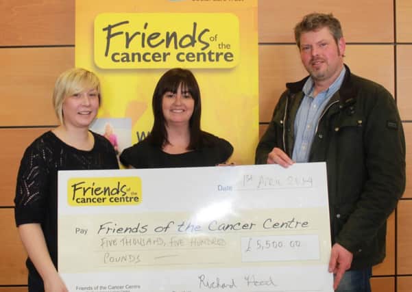 Richard Hood and his sister-in-law, Holly McGall, present a cheque to Claire Hogarth, Friends of the Cancer Centre.