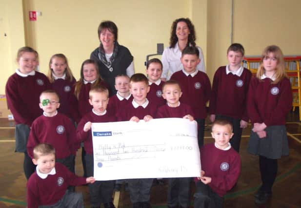 The cheque was presented to Pretty 'n' Pink representative Regina Con (back right) by P3 teacher Mrs Duffield and pupils representing P1 - P7.