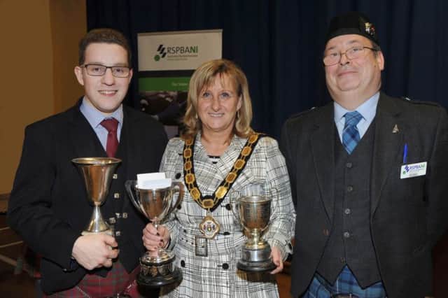 Kris Coyle from Ballyclare (left), a member of Field Marshal Montgomery Pipe Band, was crowned Ulster Senior Piping Champion at the 2014 Ulster Solo Piping and Drumming Championships, which were held in Monkstown Community School on Saturday, April 12. He is pictured receiving the winning silverware from Deputy Mayor Dineen Walker and Ray Hall, RSPBANI Chairman. INNT 16-507CON Pic by John Kelly