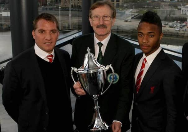 Liverpool boss Brendan Rodgers and star player Raheem Sterling pictured with Dale Farm Milk Cup Chairman Victor Leonard at last year's tournament draw in Belfast.