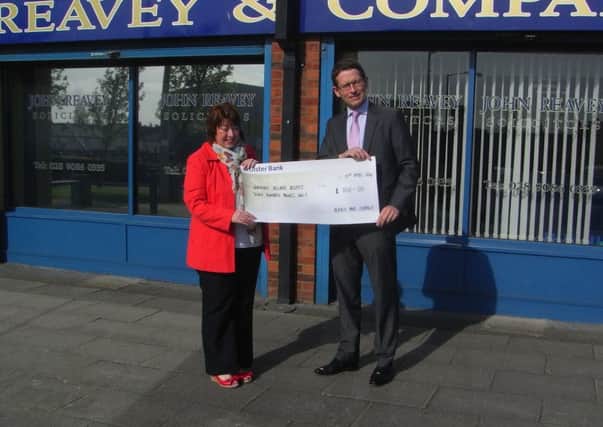 Sharon Gorman from NI Hospice receives a cheque for £700 from David Kernaghan of Reavey & Company Solicitors, Rathcoole. INNT 17-501CON