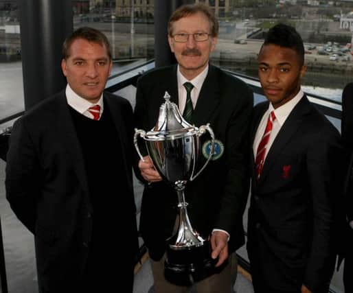 Liverpool boss Brendan Rodgers and star player Raheem Sterling pictured with Dale Farm Milk Cup Chairman Victor Leonard at last year's tournament draw in Belfast.