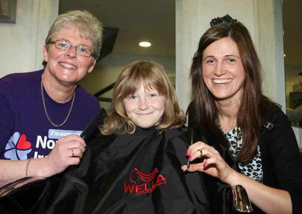 Young Josh Coates about to have his long hair cut and donated to charity to help make wigs for children with cancer, and also raising money for the NI Childrens Hospice. Josh is pictured with stylist Tracey Stewart and Catherine O'Hara (NI Hospice). INBT18-232AC