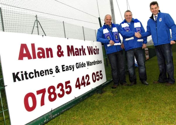 David Macauley, Commercial Manager and Geoff Cochrane, Fundraising Co-ordinator of Moneyslane Football Club, thank Alan Weir Proprietor of Weir Kitchens and Easy Glide Wardrobes, for the sponsor board recently erected a Jubille Park, Moneyslane.  © Photo; Gary Gardiner.  CS1414304.