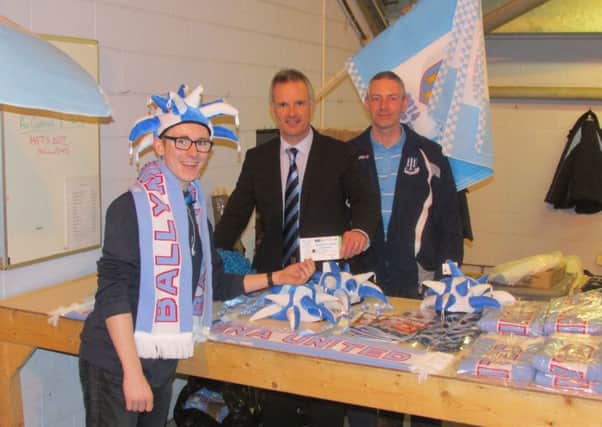 Daniel Parkinson purchases his Irish Cup final ticket from Development Committee members Nigel McIlrath and Ivan Russell.