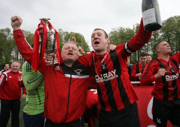Harryville Homers manager Robert Duddy and captain Gary Bonnes celebrate after lifting the Irish Junior Cup on Monday. INBT19-316AC