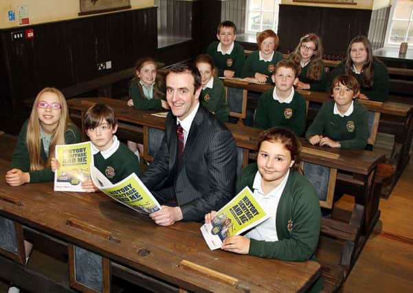 Mark Durkan, Minister of Environment, takes a seat with pupils from Gracehill Primary School in the "Old School room" last week during his visit to see the work his department funded. INBT 20-807H