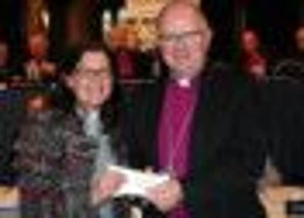 Rev Katie McAteer receives the prize from Archbishop of Armagh, Richard Clarke.