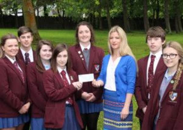 Mrs J Allen with some members of the Health Committee handing over a cheque for £1630 to the Merryn Lacy Trust Fund. The money was raised through a bun sale, canteen bucket collections and a non-uniform day.