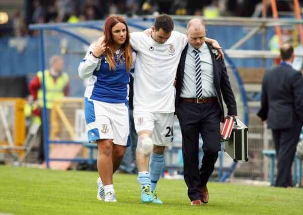 Jim Ervin is helped off the pitch at the Irish Cup final by Ballymena United medical staff Suzanne Rollins and Stephen McCurdy. The defender faces a lengthy spell on the sidelines with cruciate knee ligament damage.