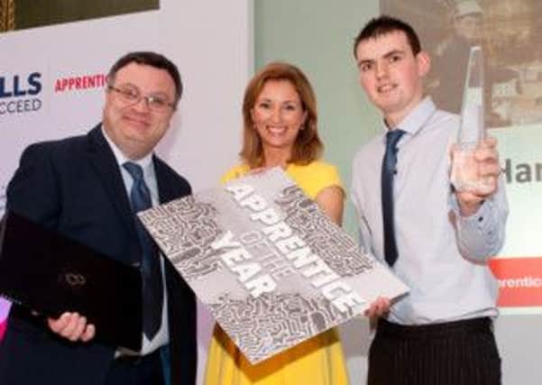 Gareth Harkness, an apprentice Engineer from Ballymena, has been crowned Apprentice of the Year 2014. Pictured are Gareth Harkness, Employment and Learning Minister Dr Stephen Farry and TV presenter Claire McCollum.