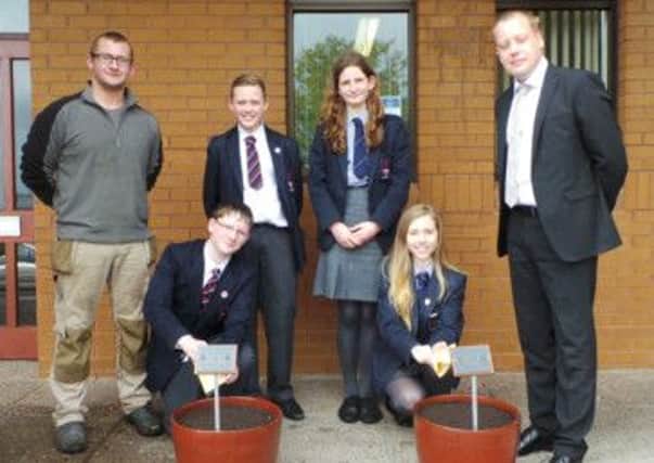 Larne Grammar School groundskeeper Mark McIlherron (left) with Principal Jonathan Wylie and Year 10 pupils planting poppy seeds to mark the centenary of the outbreak of the First World War.  INLT 21-675-CON