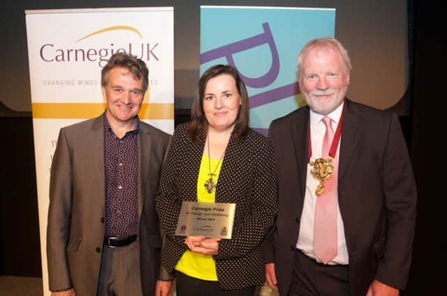Robin Watson (left) of Carnegie UK Trust and Iain Connelly (right), President of RIAS awarding the Carnegie Prize for Design and Wellbeing to Rosalind Lowry (centre) from the Ballymena Arts Partnership