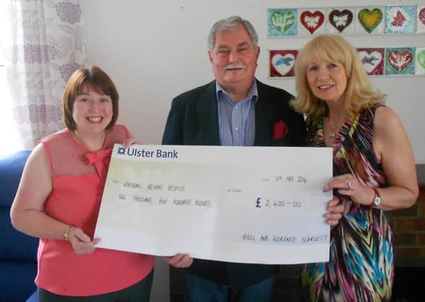 Ballyclare couple Nigel and Florence Scarlett hand over a cheque for £2,400 to Sharon Gorman of NI Hospice (left). INNT 21-515CON