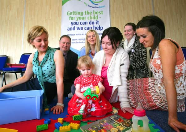 Megan McCaugherty plays with blocks at the PHA and EIL consultation event, with mum Alice McCaugherty, Mabel Scullion from the PHA, Vince Curry, Frances Jordan, Gillian Lewis, and Paula Kirby