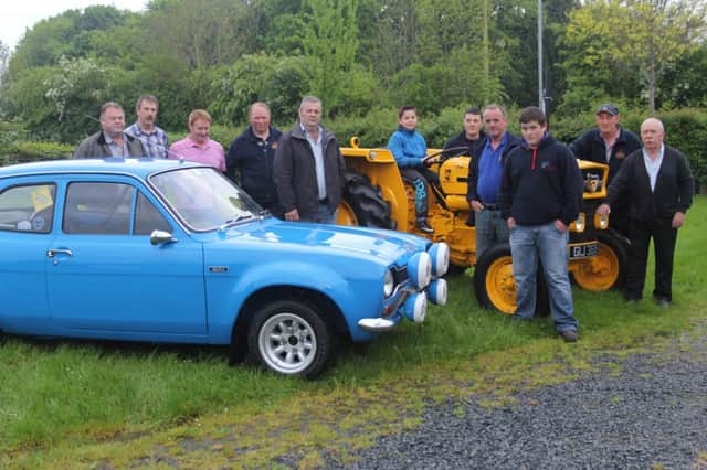 Members of the Dromara Vintage and Classic Club admire two of the vehicles to be shown - a 1972 Ford Escort and a 1975 MF Industrial tractor. Seated on the tractor is 10-year old Jamie Flanagan.