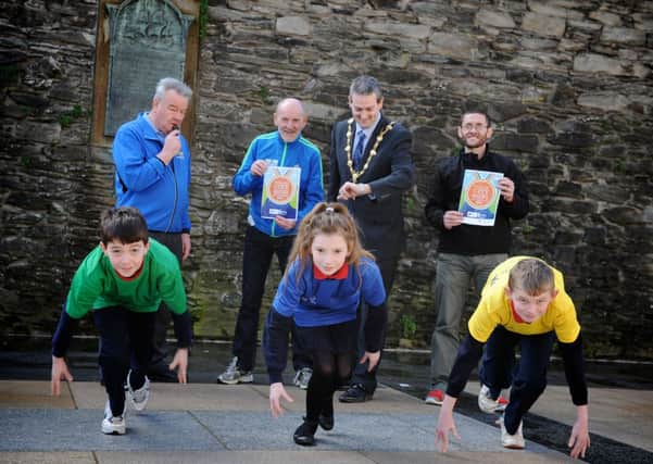 GET SET GO !!! . . . . The Mayor of Derry, Councillor Martin Reilly starts the clock on Sean McCallion, Cara Lynch and Emmett Thompson from Holy Child PS at the launch of the walled City Mini Marathon. Included, are Chas Large and Gerry Lynch, organisers od the SSE Airtricity Walled City Mini Marathon and Tommy McCallion, Derry City Council.  
DER1314SL106 Photo: Stephen Latimer