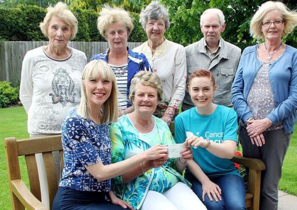 Members of the Ballymena Cancer Focus group look on as Broughshane's Betty Millar presents an £8,000 cheque to Maeve Colgan and Suzie McIlwaine of Cancer Focus. This brings this years total donations from the Ballymena group to £15,000. INBT 23-815H