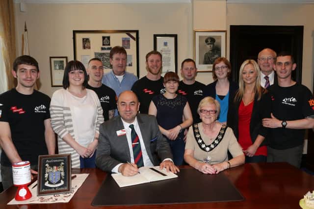 David Forsey of ABF The Soldiers' Charity, signs the Visitors book at a reception hosted by Mayor of Ballymena Cllr Audrey Wales for local men who are embarking on the grueling Five Peaks Challenge to raise funds for ABF. The team of Adam Dunlop, Jonathan Clail, Philip Gillespie, Dave Kane, and Andy McFarland were accompanied by Nichola Elder,  Robert Gillespie, Kirsty Crawford, Claire Todd, Gemma McFarland and Cllr Hubert Nicholl. INBT 23-101JC