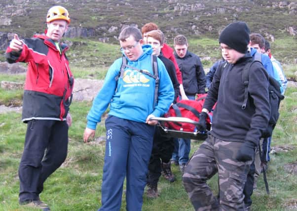 Broughshane scouts carefully carry their Slemish casualty to safety under the watchful eye of a member of the NW Mountain Rescue.