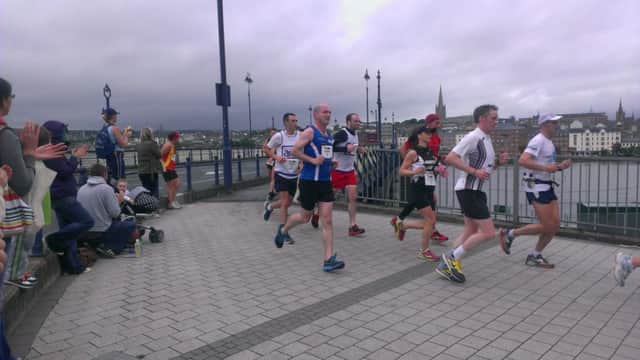 Runners cross the Craigavon Bridge in the Walled City Marathon