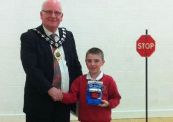 Adam Welsh of Woodburn Primary School, who was third in the Safe Cycle challenge, receives his prize of bicycle lights from the Mayor of Carrickfergus, Alderman Billy Ashe. INCT 23-796-CON