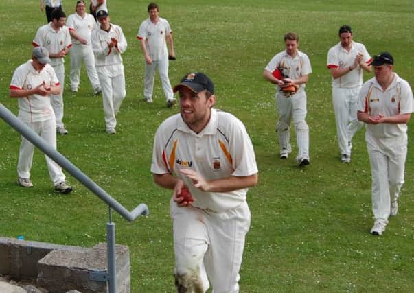 John Guy leads the Lurgan team off at Dundrum having hit 94 not out. He went on to take 6 wickets for 27 runs.